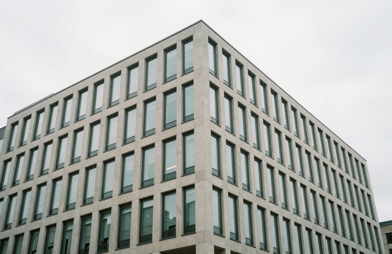 Facade of a modern mid-rise commercial office building in pale stone and glass