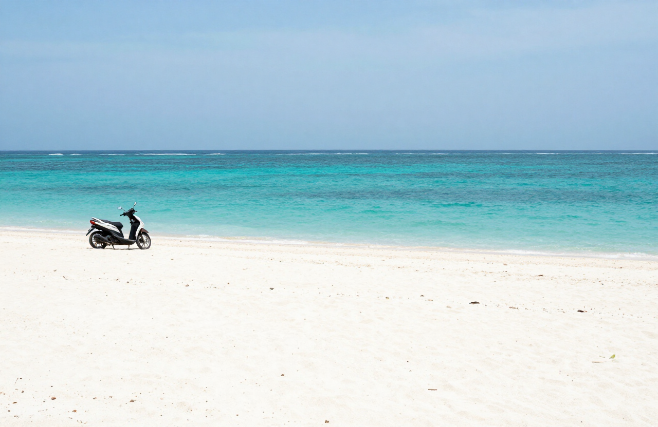 An empty white-sand cove near Tanjung Aan, Lombok, with a single scooter parked on the sand