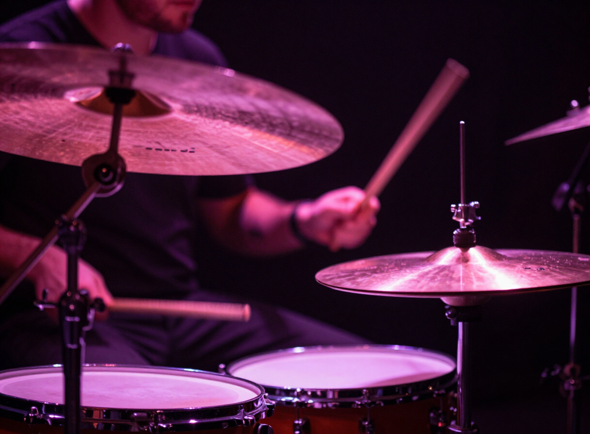 Drummer seen through transparent cymbals with magenta light and blurred sticks