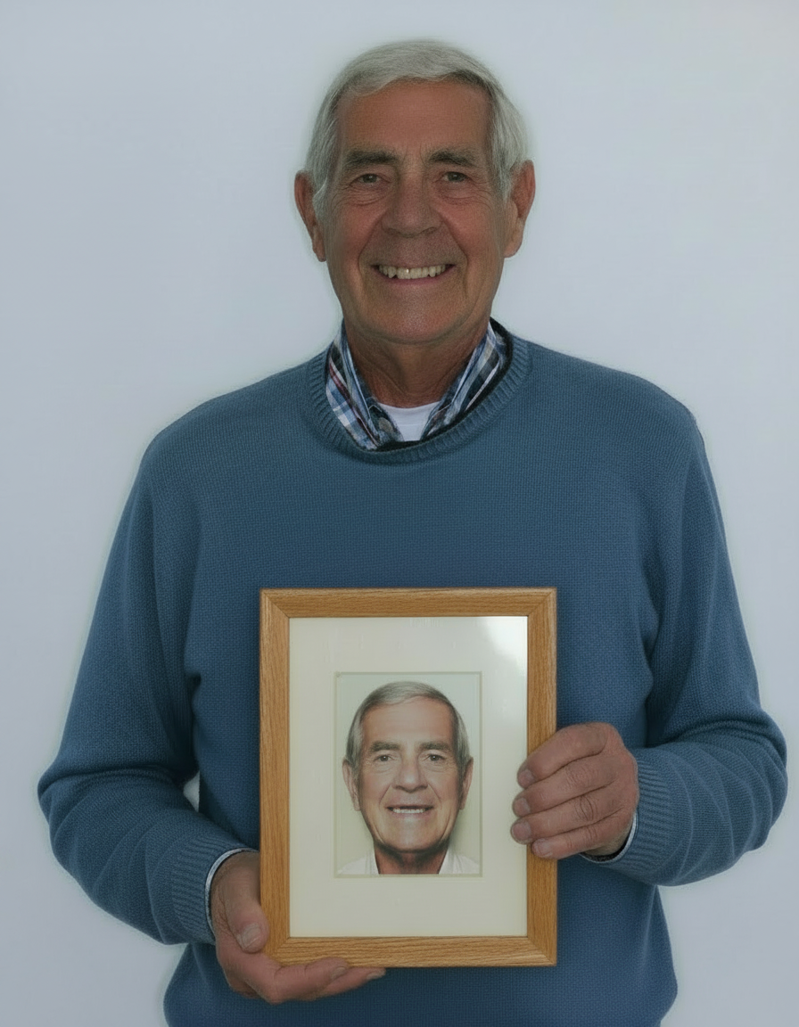 Patiënt met zijn nieuwe vaste tanden houdt een fotolijst vast met zijn eerdere glimlach